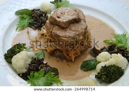 Veal / beefsteak  on vegetable bed served with wild rice, broccoli and cauliflower
