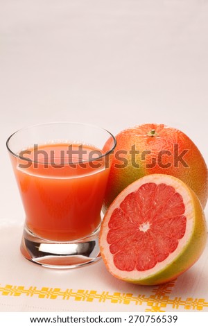 Red grapefruit and a glass of grapefruit juice isolated on white background