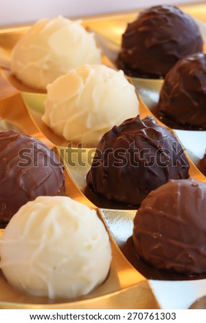 Closeup of  ball-shaped chocolates made with black chocolate, white chocolate and milk chocolate