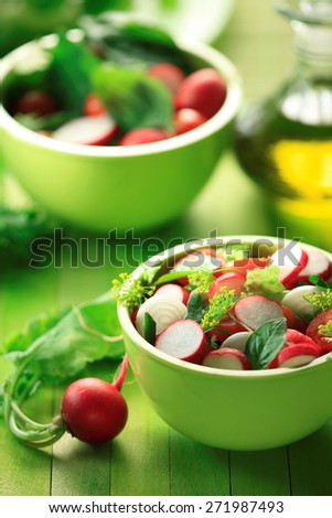 Radish salad with  Rocket leaves and spinach  in a green bowl