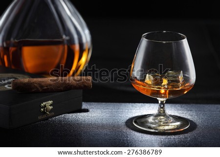 Whiskey glass, whiskey bottle, cigar, whiskey on the rocks