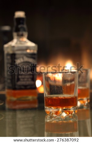 Whiskey bottle and whiskey glass near the fireplace