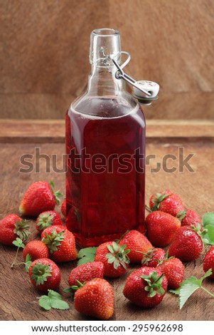 Strawberry liqueur / wine bottle and fresh strawberries
