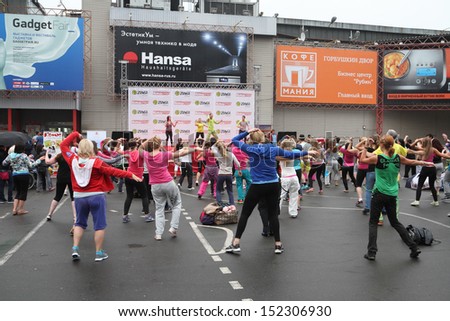 MOSCOW, RUSSIA - AUGUST 30: People dance under slight rain during Zumba training fitness on Gorbushkin Dvor gymnasium yard on August 30, 2013 in Moscow.