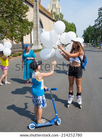 MOSCOW - AUGUST 2:  Girl giving balloons to boy at VDNKh in Moscow on August 2, 2014. VDNKh (called also \
