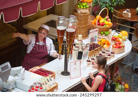 MOSCOW - JULY 29: The seller of fruits, juices and soft drinks talking with the buyer to the GUM store on July 29, 2014 in Moscow.