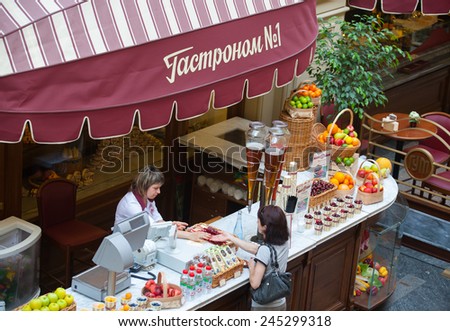 MOSCOW - JULY 29: The seller of fruits, juices and soft drinks allowing delivery to the buyer in the GUM store on July 29, 2014 in Moscow.