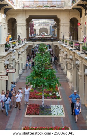 MOSCOW - JULY 29: Artificial trees and walking people in the GUM store on July 29, 2014 in Moscow. GUM is the large store in the Kitai-gorod part of Moscow facing Red Square.