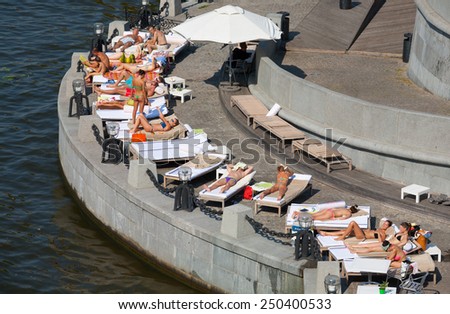 MOSCOW - JULY 31: People lying on the couches and sunbathing at Olive Beach in Gorky Park on July 31, 2014 in Moscow. Olive Beach is located on the bank of Moskva River.