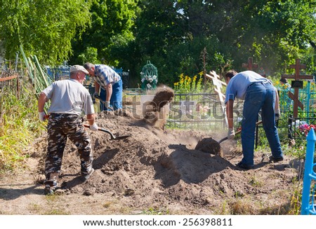 BESTUZHEVO, RUSSIA - AUGUST 26: Gravediggers digging the grave on August 26, 2014 in Bestuzhevo village.