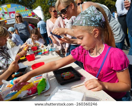 MOSCOW - AUGUST 24: Children making cakes during celebration Apple Feast Day in VDNKH Park on August 24, 2014 in Moscow. Savior of Apple Feast Day is an Eastern Slavic folk holiday.