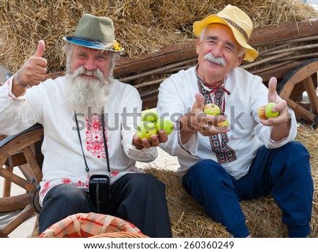 MOSCOW - AUGUST 24: Senior men dressed in national costumes celebrating Apple Feast Day in Park VDNKH on August 24, 2014 in Moscow. Savior of Apple Feast Day is an Eastern Slavic folk holiday.