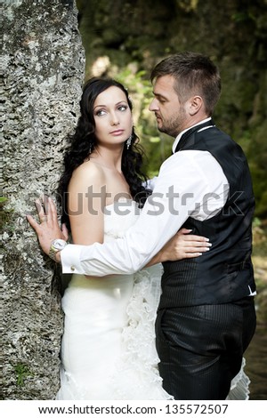 Happy young bride and groom on their wedding day.Photo session near a waterfall