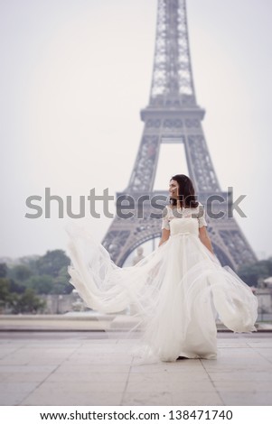 Beautiful delicate bride enjoying her wedding day in Paris, in front of the Eiffel tour