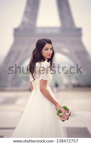 Beautiful delicate bride enjoying her wedding day in Paris, in front of the Eiffel tour