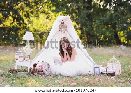 Beautiful bride dreaming on her wedding day, photo session in the nature