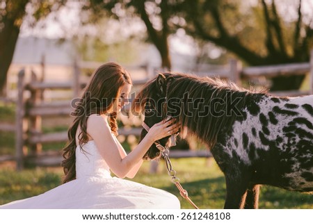 Stunning and beautiful bride looking at her horse in her wedding day