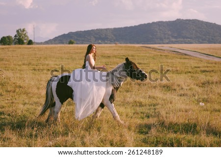 Stunning and beautiful bride riding a horse on her wedding day