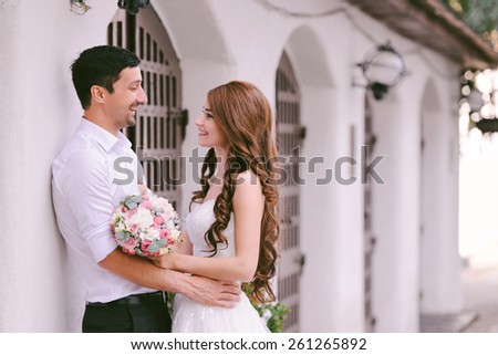 Bride and groom having a romantic moment on their wedding day, laughing and looking at each other