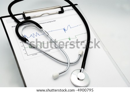 Stethoscope on clipboard over blood pressure graph printout