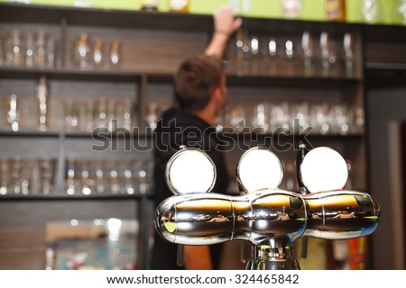 The young barman serving behind the bar (the pumping device).