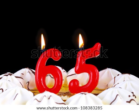 Birthday-anniversary cake with red candles showing Nr. 65