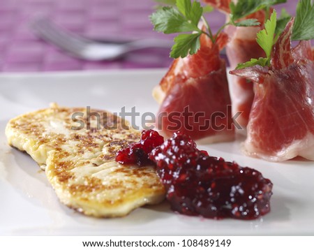 Fried fresh cheese with cured ham and raspberry marmalade. Spanish Tapa . Fried fresh cheese with cured ham and rapsberry marmalade.