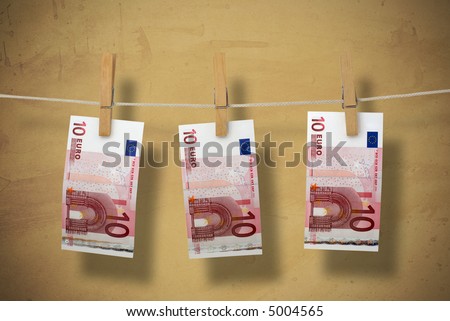 Paper money on a clothesline. Symbolizing money laundering. On texture brown background.