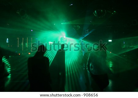 Dancing people between scanner/laser light in a disco