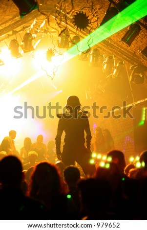 dancing man with gas mask and steel helmet dancing on a platform in a disco