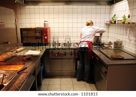 female cook in action in the kitchen of a fast food restaurant