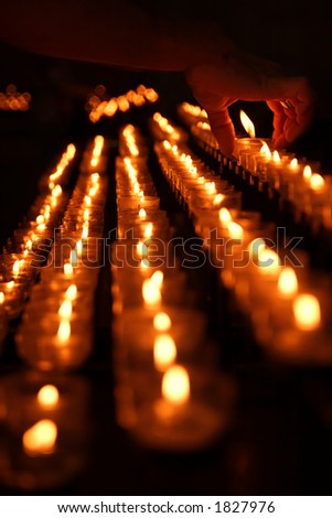 Votive candle placed by man's hand