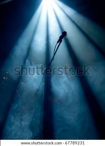 Microphone on stage with stage-lights in the background Microphone on stage with stage-lights in the background