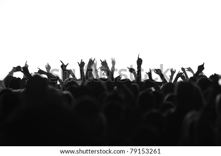 silhouettes of concert crowd in front of bright stage lights, black and white version