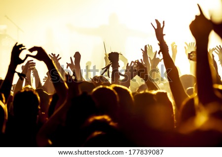 silhouettes of concert crowd in front of bright stage lights silhouettes of concert crowd in front of bright stage lights
