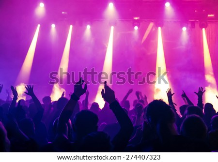 silhouettes of concert crowd in front of bright stage lights silhouettes of concert crowd in front of bright stage lights