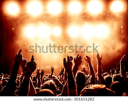 silhouettes of concert crowd in front of bright stage lights - a small DOF signifies that the focused area is narrow