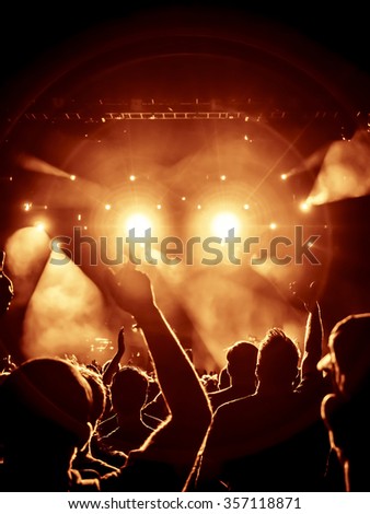 silhouettes of concert crowd in front of bright stage lights - no fine details due limited light situation