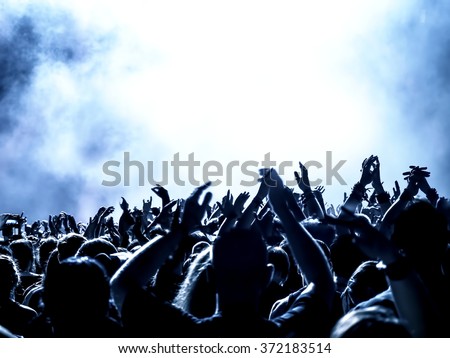 silhouettes of concert crowd in front of bright stage lights - no fine details due limited light situation
