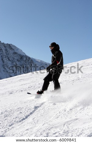 Dude in black suite ridding on snowboard