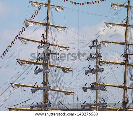 RIGA, LATVIA - JUL 28: Sailors set sails on masts of ship arrives in Latvia during \