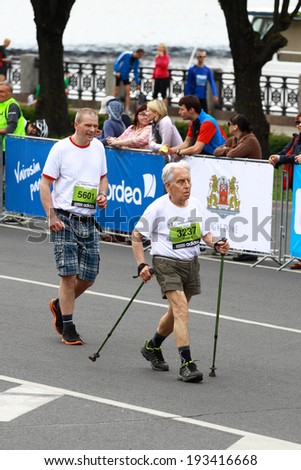RIGA, LATVIA - MAY 18: A senior participant of Nordea Riga marathon runs down the street on May 18, 2014 in Riga, Latvia. The marathon is held annually