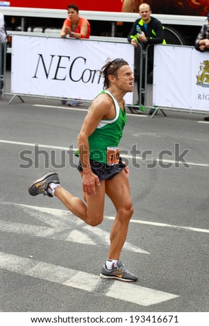 RIGA, LATVIA - MAY 18: A participant of Nordea Riga marathon runs down the street on May 18, 2014 in Riga, Latvia. The marathon is held annually
