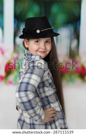Cute long haired plump round faced girl in hat portrait - children beauty and fashion concept