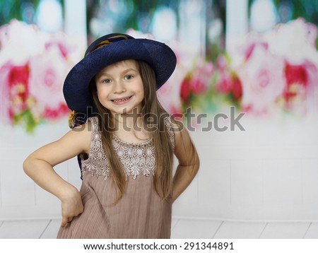Cute little girl in too big hat posing indoor with copy space