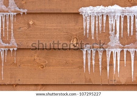 Icicles hang from a wood cabin in on a chilly winter day