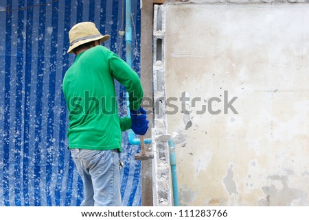 builder hitting a wall with a sledge hammer
