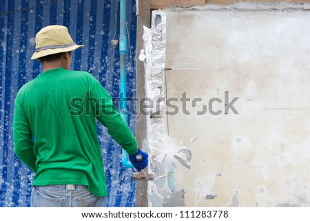 builder hitting a wall with a sledge hammer