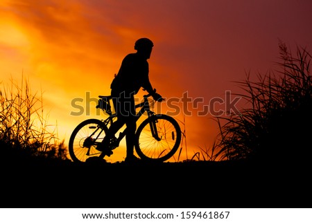 silhouette of bicycle rider at sunset