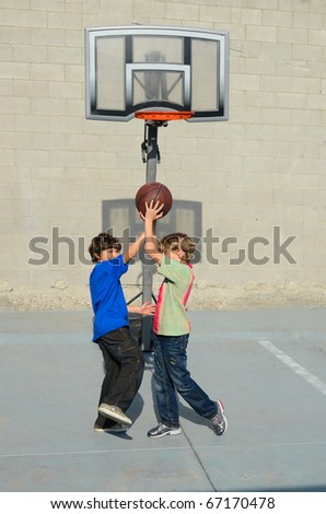 Two boys play basketball